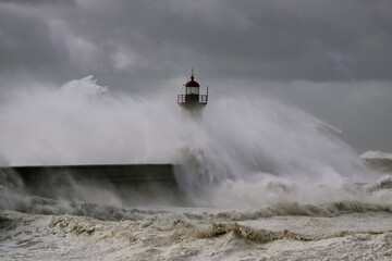 Stormy waves over piers and lighthouse