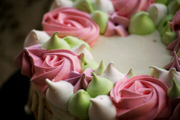 decoration of meringue cake in the form of curls and roses