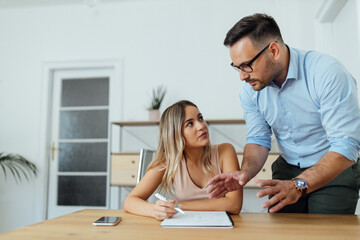 Fototapeta premium Private tutor explaining something to a female college student, portrait.