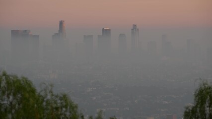Naklejka premium Highrise skyscrapers of metropolis in smog, Los Angeles, California USA. Air toxic pollution and misty urban downtown skyline. Cityscape in dirty fog. Low visibility in city with ecology problems