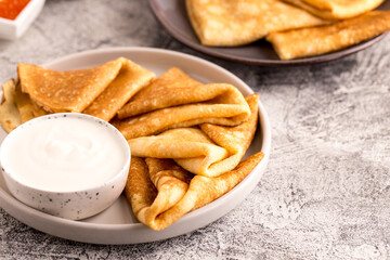Traditional Russian pancakes. Fried crepes with sour cream