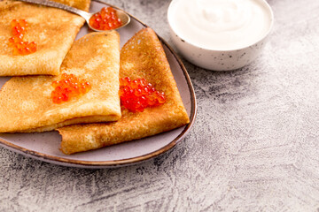 Traditional Russian pancakes with red caviar. Fried crepes with caviar and sour cream