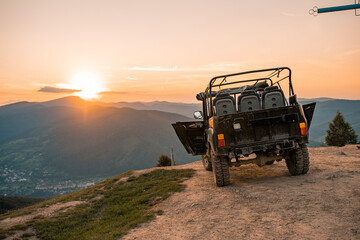 Black Jeep parked on the top of mountains at panoramic view point. Colorful sky with sunrise at sunset