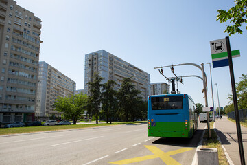 Electric bus at a stop is charged by pantograph	