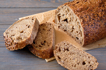 Fresh wholemeal bread with sunflower seeds, sesame and others grains on an old wooden table.