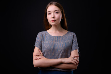 Young beautiful woman with long brown hair against black background