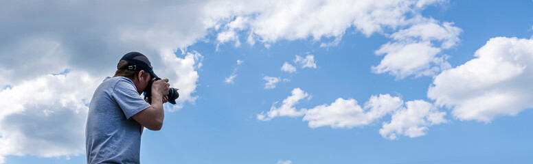 Obraz premium a male photographer shoots and photographs the sky. beautiful panorama with clouds