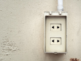 Old electrical plug installed on the cement wall. With space for place your text.