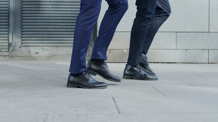 Unrecognizable businessmen taking walk on road. Business people going for job