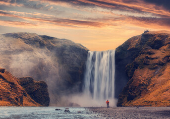 Incredible Icelandic Landscape. Famous Skogafoss waterfall with colorful sky during sunset. Skoga...