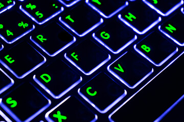 Close up view of a modern laptop computer keyboard key with blue buttonss. Pc computer keyboard close up