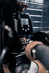 A professional barista transforms ground coffee beans into aromatic thick coffee using special machines