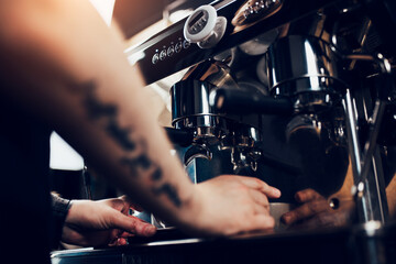 A professional barista transforms ground coffee beans into aromatic thick coffee using special machines