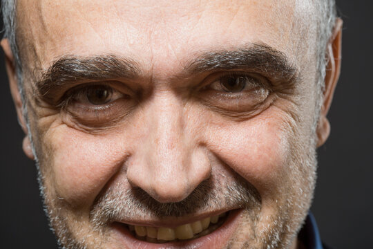 Ritratto di uomo  di mezza et&agrave; sorridente , isolato su sfondo nero 