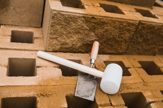 Trowel and mallet - working tools of a professional bricklayer in the workplace