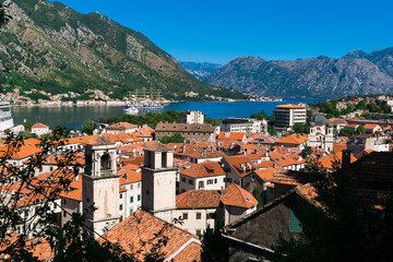Naklejka na ściany i meble Kotor bay view in Montenegro, summer time. Kotor town. Mountains, water, red roofs of the old city below. Tourist route to the height. Observation decks on the way.