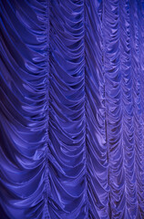 Large purple curtain with spot light and fading into dark.