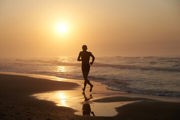 A man running in the morning along the coast of the sea
