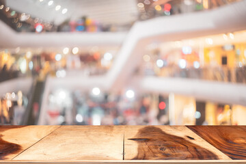 Wooden tabletop on blur people walking in shopping center mall abstract background.