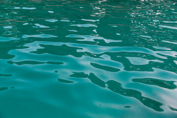 Sea background. Light blue and dark blue colors. Sun reflection on water.