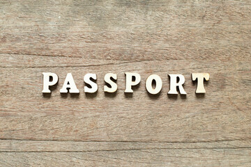 Alphabet letter block in word passport on wood background
