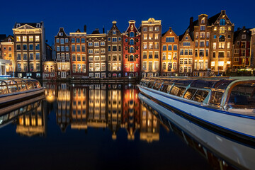 Amsterdam houses along the Damrak in the Netherlands at night