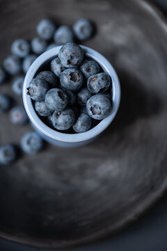 minimalistic top view fresh blueberries on dark background ceramic plate