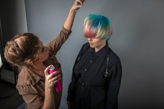 Girl hairdresser styling hair girl with rainbow hair beauty fashion style