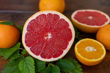 oranges and grapefruit on a brown wooden background, top view, text space, citrus