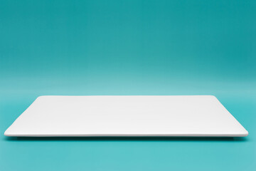 A rectangle empty white plate isolated on the tiffany blue background.