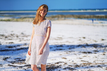 Woman in dress on white sandy beach