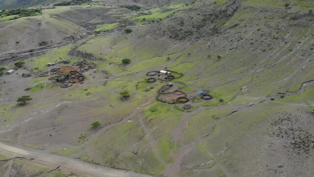 Aerial Flyby View on the Maasai village in front of the Ol Doinyo Lengai, Mountain of God in the Maasai language, Engare Sero village in Arusha Region i the Northern Tanzania, Africa, at Sunset time.