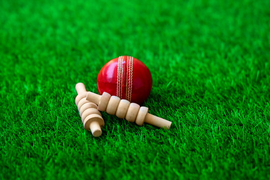 cricket ball and bails on green grass pitch