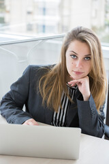 manager bionda vestita in giacca scura è seduta nella sua postazione di lavoro mentre guarda seria