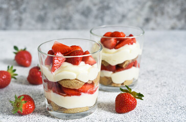 Strawberry tiramisu in a glass on a concrete background. Classic Italian dessert.
