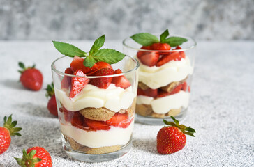 Strawberry tiramisu in a glass on a concrete background. Classic Italian dessert.