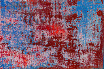 Bright colorful background from rusty metal with old blue and red shabby cracked paint, atmospheric impact, outdoors, horizontal photo.