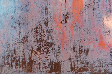 Rusty metal background with old red peeling cracked paint, atmospheric impact, outdoors, horizontal photo.