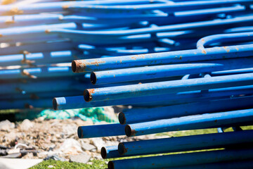 Blue stack of steel pipe scaffold at construction site.