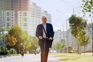 Senior businessman riding electric scooter in a cityscape   