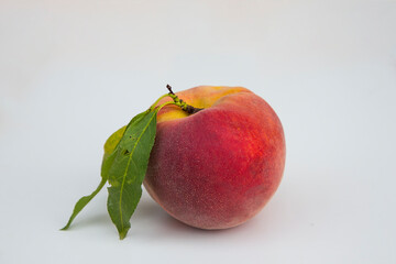 Fresh domestic bio peach fruit with green leaves