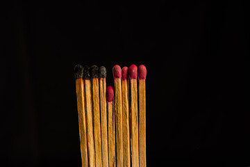 one in the crowd concept of matchstick with flames,