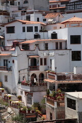 Fototapeta na wymiar View of white and red houses with tile roofs on hill in Taxco, Mexico 