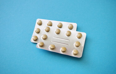 Pills in blister packs, vitamines. Pharmaceuticals antibiotics pills medicine on blue background. Drug store. Pharmaceutical industry concept.