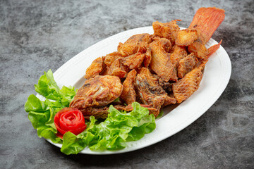 Crispy tilapia fish cooked with herbs, lemongrass, kaffir lime leaves and table sauces.