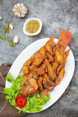 Crispy tilapia fish cooked with herbs, lemongrass, kaffir lime leaves and table sauces.