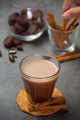 Cocoa served with a delicious chocolate dessert on a black background..