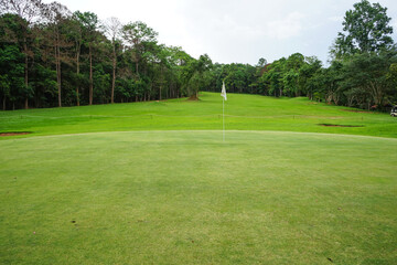 Obraz premium Background of evening golf course has sunlight shining down at golf course in Thailand. Nice scenery on a golf course at a late summer afternoon