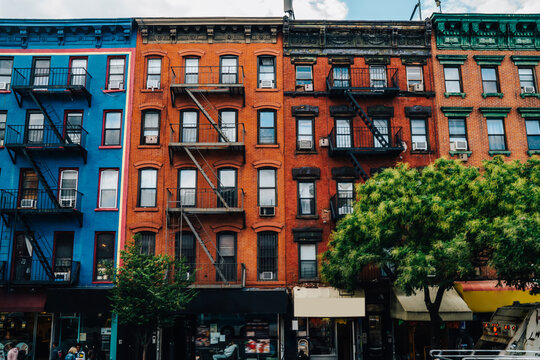 Houses from colourful bricks with residential and commercial real estate for rent in Brooklyn, beautiful vintage buildings with apartments and property for stores and shops on street in New York .