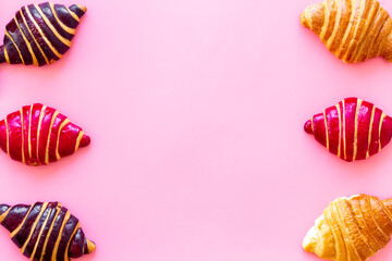 Frame of croissants - fresh bakery on pink background. Top view